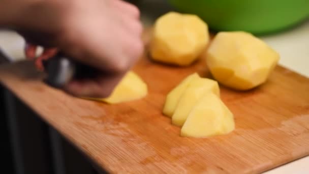 Fechar a mão com faca cortando vegetais frescos. Mulher de corte de batatas em uma placa de corte branco closeup
. - Filmagem, Vídeo