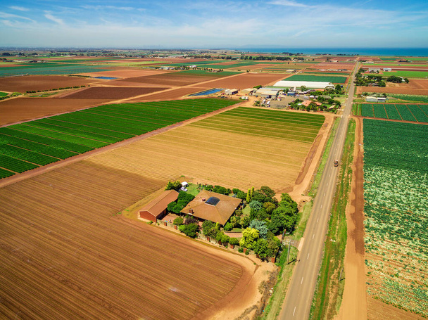 Luftaufnahme von Bauernhaus und landwirtschaftlichen Feldern - gepflügt und mit Getreide an einem strahlenden Sommertag in Australien - Foto, Bild