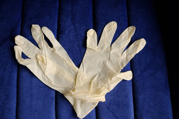 Gants blancs en latex sur fond bleu. Protection des mains contre les infections, les virus, les germes. Isolement de la peau du coronavirus
. - Photo, image