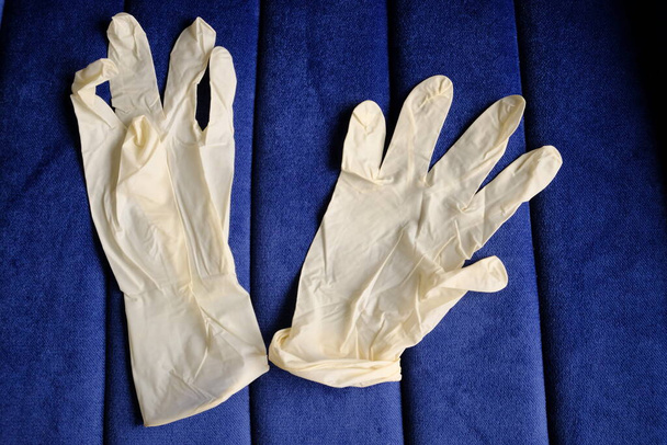 Белые, латексные перчатки на синем фоне. Защита рук от инфекций, вирусов, микробов. Изоляция кожи от коронавируса
. - Фото, изображение