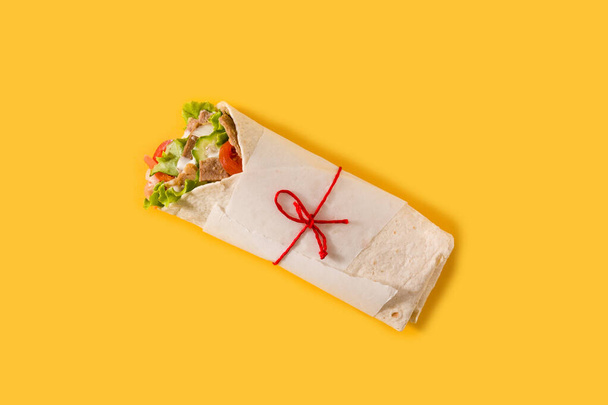Sandwich Doner kebab o shawarma aislado sobre fondo amarillo. Vista superior
 - Foto, imagen