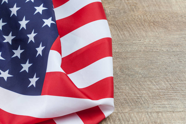 Die amerikanische Flagge faltet sich auf einem Holztisch aus Walnussbaum. Horizontales Bild mit Kopierraum. - Foto, Bild