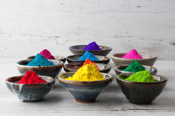 Vivid colorful Holi dye powder in cups. Shallow depth of field. - Valokuva, kuva
