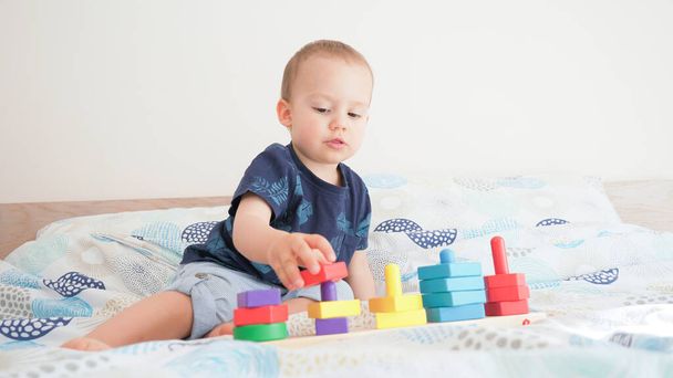 Słodki mały maluch robi ćwiczenia mózgu. Baby boy gry rozwój montessori gry.  - Zdjęcie, obraz