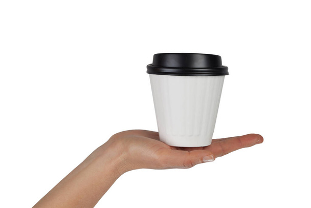 Female hand with white disposable coffee cup in the palm isolated on white with copy space - Fotoğraf, Görsel