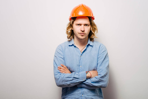 Handsome young man with protective helmet on his head and arms crossed - Фото, изображение