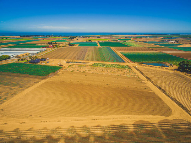 Scenic aerial landscape of plowed fields and crops near ocean coastline on bright summer day. Werribee South, Victoria, Australia - Φωτογραφία, εικόνα