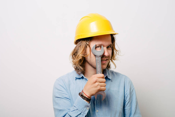 Portrait of young handyman holding a wrench - Фото, изображение