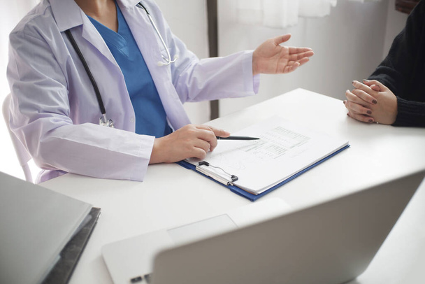 Female medicine doctor working on table with consulting patient. - Photo, Image