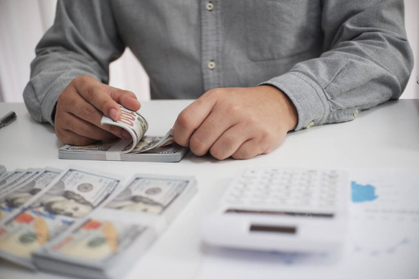 Homme d'affaires méconnaissable, comptable, banquier comptant l'argent sur le lieu de travail, fond blanc. - Photo, image