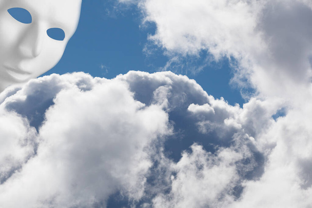 Λευκή μάσκα πάνω από αφράτα σύννεφα που κοιτούν κάτω. Θεϊκή παρέμβαση - Φωτογραφία, εικόνα