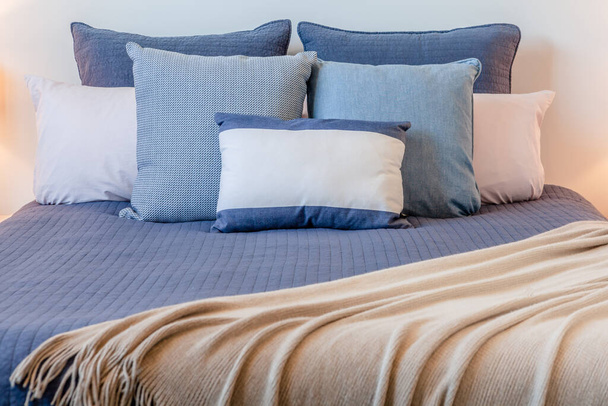 Beautiful arrangement of pillows on bed in a bedroom with copy space - Φωτογραφία, εικόνα