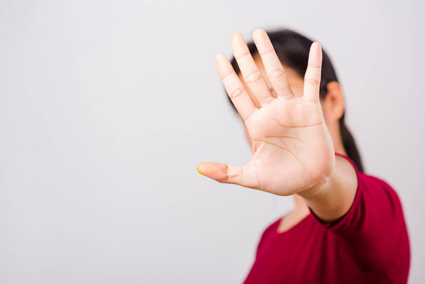 Asian beautiful woman itching her outstretched hand showing stop gesture front face, focus on hand on white background with copy space - Φωτογραφία, εικόνα
