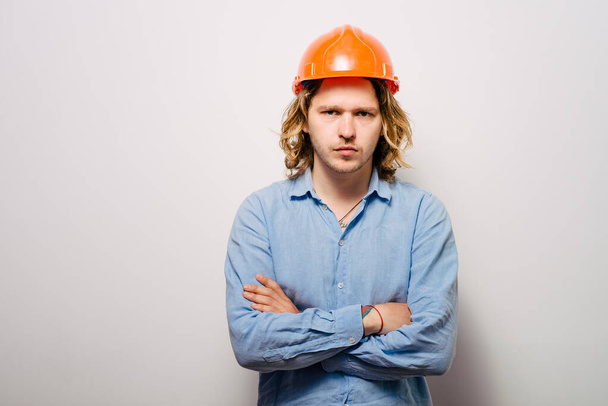 Handsome young man with protective helmet on his head and arms crossed - Foto, imagen