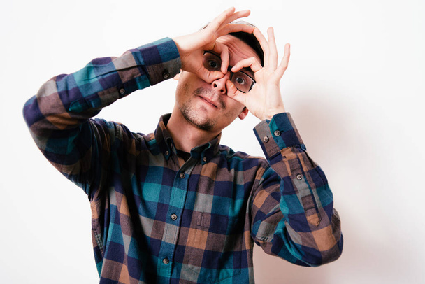 man looking through hands, making binoculars - Foto, Imagem