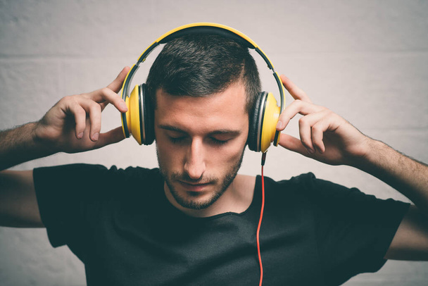 Man with headphones against studio background - Fotoğraf, Görsel