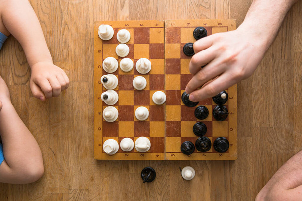 Vater und Sohn spielen zu Hause gemeinsam Schach - Foto, Bild
