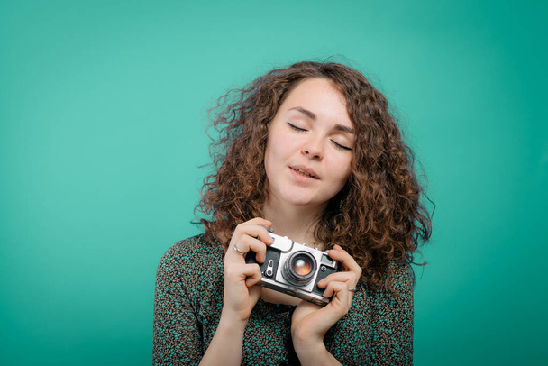 Woman with camera against studio background - Foto, afbeelding