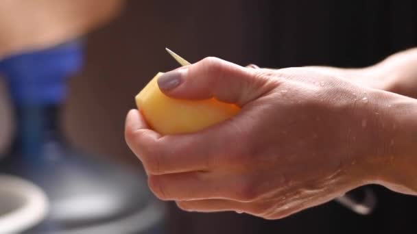 female hands peeling potatoes with knife - Filmati, video