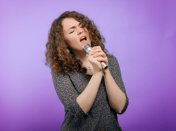 Fiatal lány énekel mikrofonnal - Fotó, kép