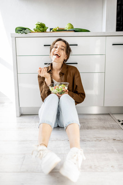 Женщина со здоровой пищей на полу кухни
 - Фото, изображение