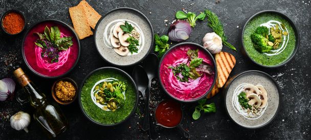 Vegetarian set of soups. Beet soup, broccoli cream soup and mushroom soup. Top view. Free space for your text. On a black stone background. - Foto, immagini