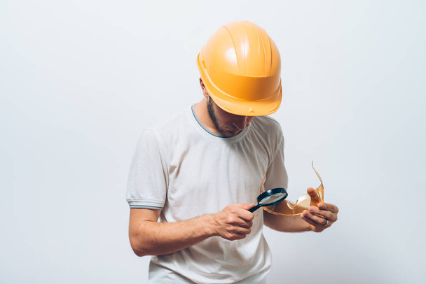 builder with magnifying glass - Фото, зображення