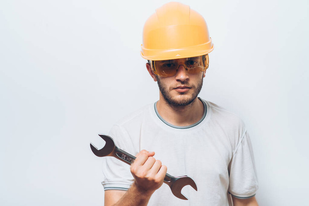 Portrait of young handyman holding a wrench - Фото, зображення