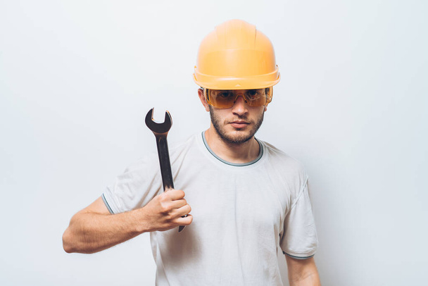 Portrait of young handyman holding a wrench - Fotó, kép