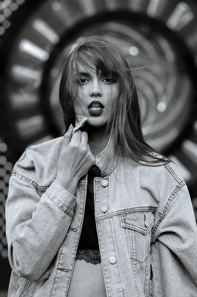 Lifestyle shot of seductive young woman with red lips wears jeans jacket. Monochrome color - Foto, immagini