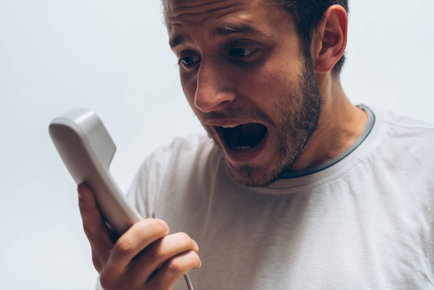 Close up image of a man screaming on the telephone during the conversation. - Valokuva, kuva