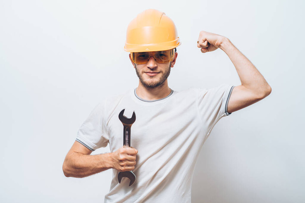 Portrait of young handyman holding a wrench - Valokuva, kuva