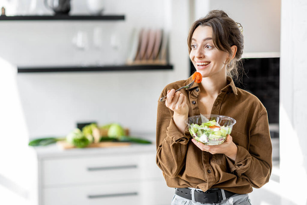 Mujer con ensalada saludable en la cocina - Foto, imagen