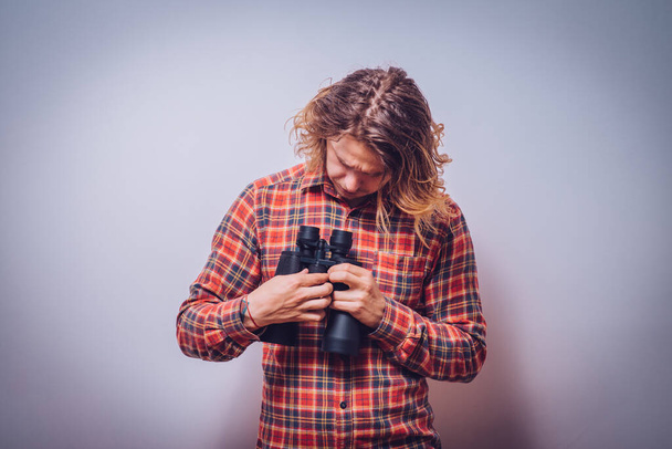 man with binoculars. gray background - Zdjęcie, obraz