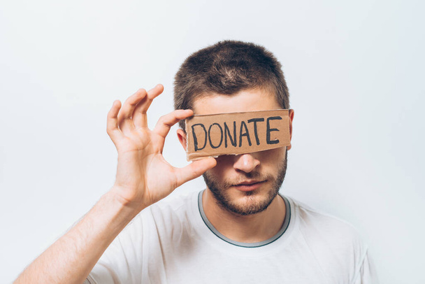 male, cardboard sign donation. On a gray background - Valokuva, kuva