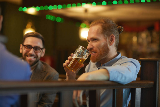 Egy férfi sört iszik a barátaival. - Fotó, kép
