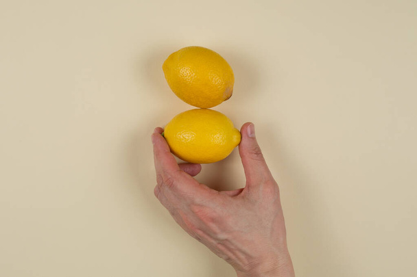 two lemons, the fruit for the immune system, fighting the virus on a yellow background - Φωτογραφία, εικόνα