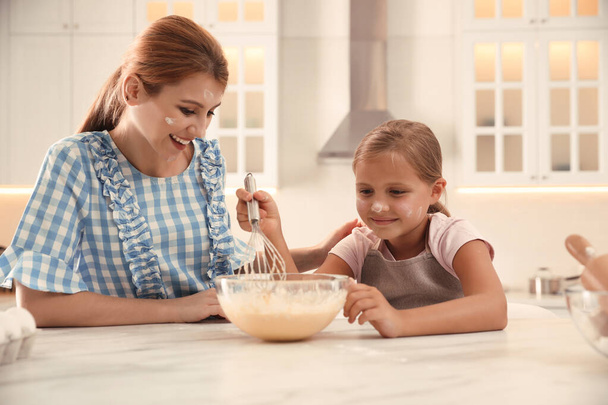 Mother and daughter making dough together in kitchen - Φωτογραφία, εικόνα