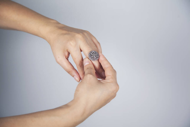young woman finger ring on gray background - Foto, afbeelding