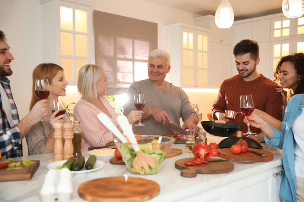 Счастливые люди готовят еду вместе на кухне
 - Фото, изображение