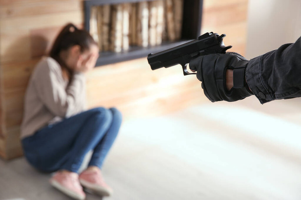 Man aiming his victim with gun indoors, closeup. Dangerous criminal - Valokuva, kuva