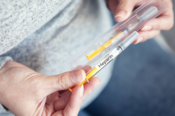 Woman's hands hold disposable syringe with heparin - Photo, Image