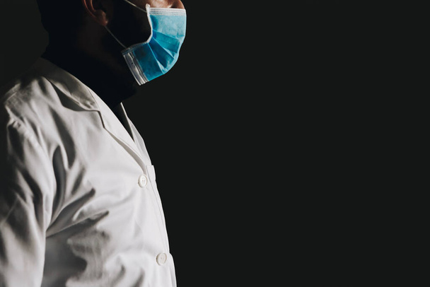 Panoraama lääketieteellinen koronavirus banneri tilaa tekstiä. Tunnistamaton väsynyt avustaja, lääkäri COVID 19 katselee ikkunasta mustalla pohjalla
 - Valokuva, kuva
