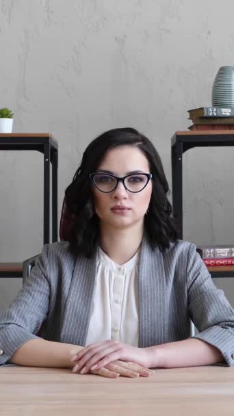 girl in a suit and glasses sits in the office at the desk - Filmati, video