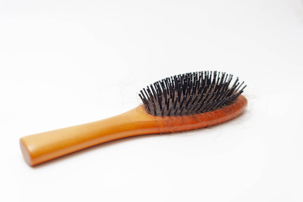 Escova de cabelo de madeira com um monte de cabelos castanhos isolados no fundo branco
. - Foto, Imagem