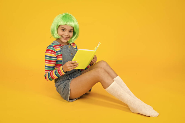 Relax and read book. Adorable small child read book yellow background. Cute little girl enjoy reading. You cant buy happiness but you can buy book. Book store. Library. Bibliopole - Foto, imagen