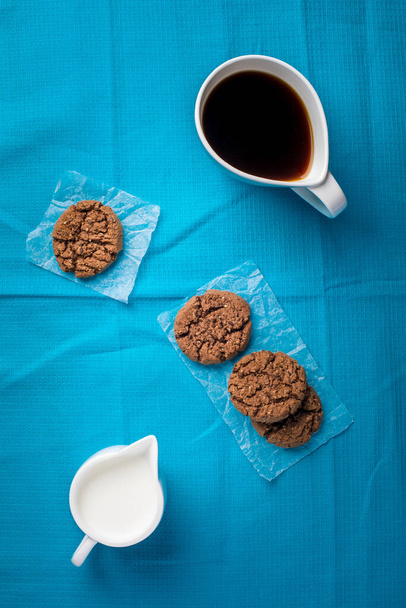 Чашка кофе, шоколадные конфеты и печенье на столе
 - Фото, изображение