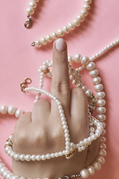 Hermosas manos femeninas con manicura sosteniendo perlas. Mujer mostrando las manos con elegante manicura femenina de moda. Cuidado de la piel
 - Foto, imagen