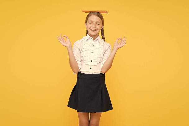 Dealing with school stress. Practice meditation. Find balance. Harmony concept. Peace and balance. Hope for best. School girl studying textbook. Kid school uniform hold book. Life balance positivity - Foto, imagen