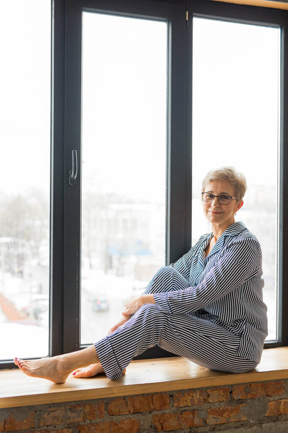  beautiful stylish elderly woman sits by the window - Fotó, kép